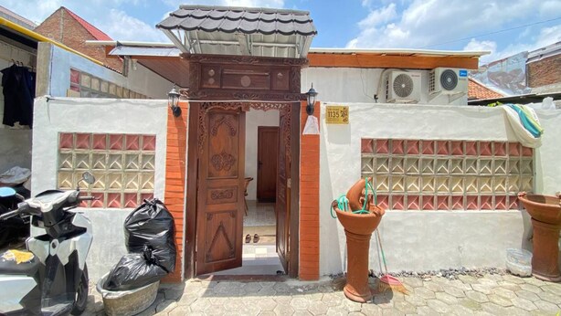 A residential property with a wooden gate, a tiled roof, and a tiled wall with a geometric pattern. - Capital O 94840 Unihomestay Malioboro (Yogyakarta)