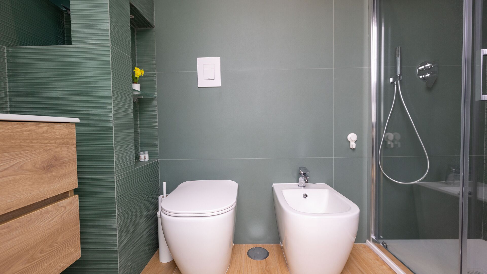 Een moderne badkamer met toilet, hygiëneschuimer en douche.