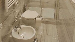 Un baño moderno con ducha envuelta en vidrio, inodoro y lavamanos.