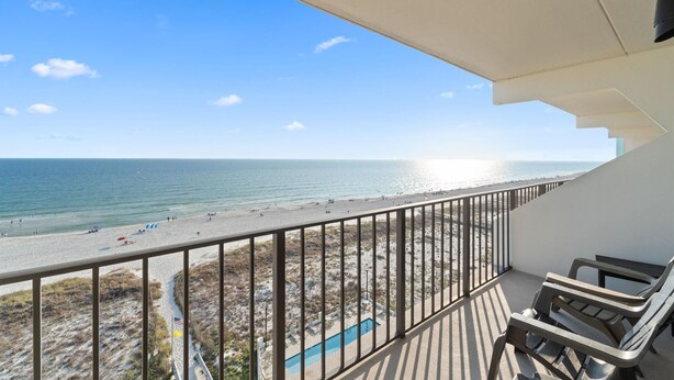 Un balcon avec vue sur une plage et l’océan.