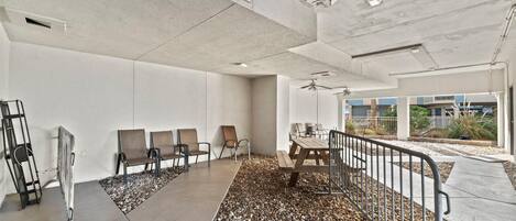 A modern indoor space with a concrete ceiling, a table with chairs, and a seating area with benches.