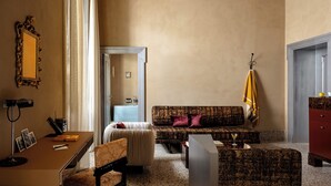 A room with a sofa, armchair, desk, and a mirror. - Experimental Roma (Rome)