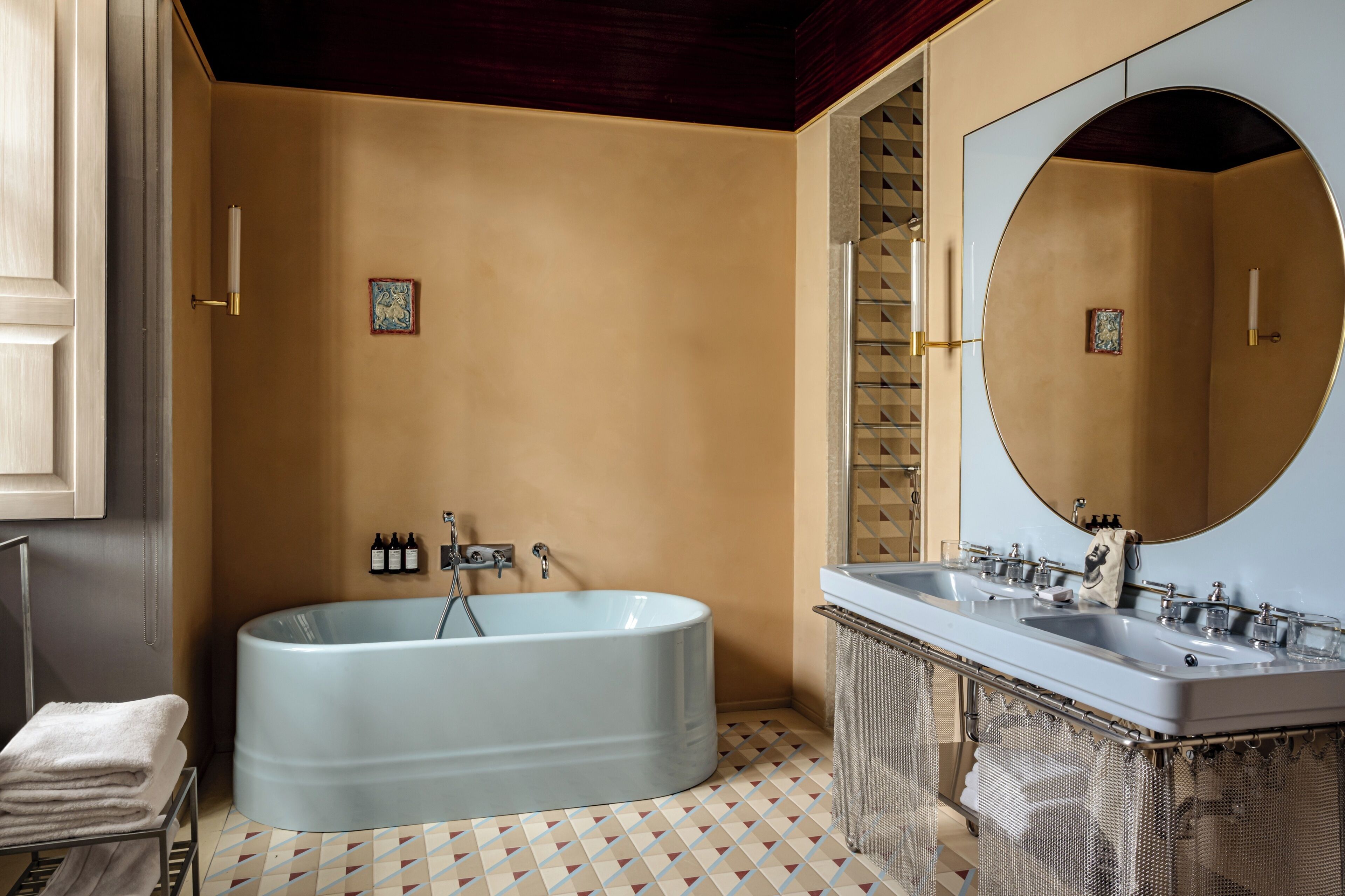A bathroom with a freestanding bathtub, a double sink vanity, and a large mirror.