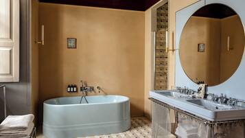 A bathroom with a freestanding bathtub, a double sink vanity, and a large mirror.