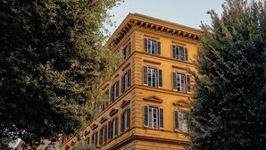 A multi-story building with classical architecture, featuring symmetrical windows and a central entrance. - Experimental Roma (Rome)