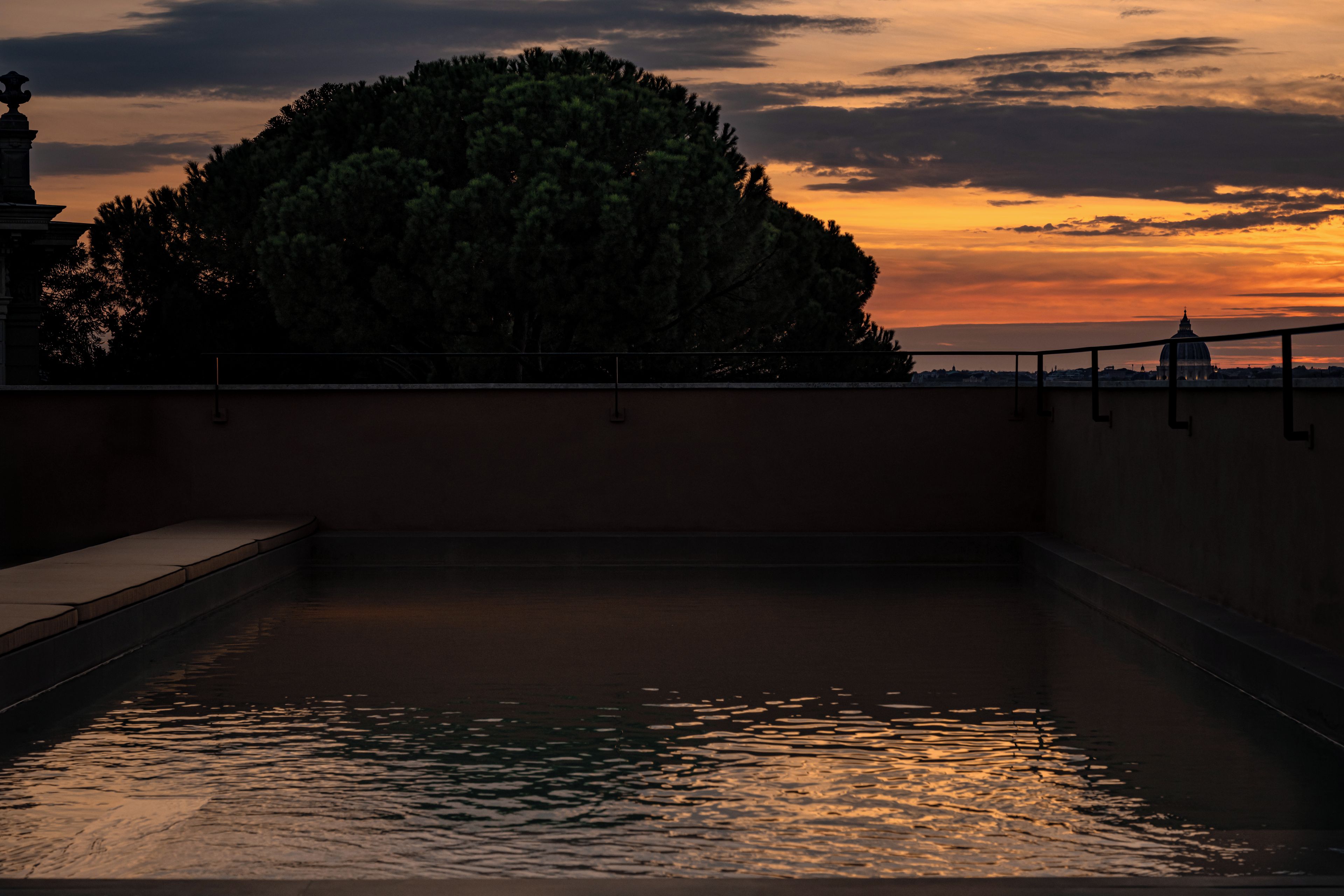 Una piscina rectangular con una vista despejada del cielo y un edificio distante.