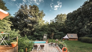 A backyard with a wooden deck, a swimming pool, and a small wooden structure. - GLAMPING PIAN DELLE GINESTRE (Sassetta)