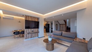 Uma sala de estar moderna com um sofá, uma mesa de centro e um espaço de jantar com cadeiras e uma mesa.