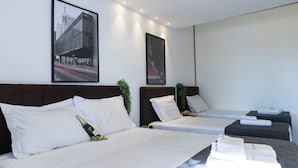 A hotel room with two beds, a large window, and two framed pictures on the wall. - Casa a 450m Parque Ipiranga (São Paulo)