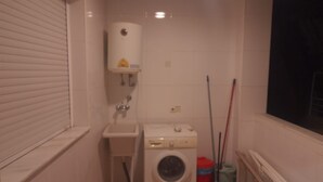 A small laundry room with a washing machine, a sink, and a window. - Apartment 'Piso Centroolula' with Balcony and Air Conditioning (Olula del Río)