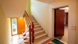 A staircase with wooden handrails leading to a landing. - Casa Shiva (Sedico)
