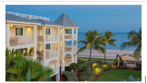 Ein mehrstöckiges Hotel mit Balkonen mit Blick auf einen Strand.