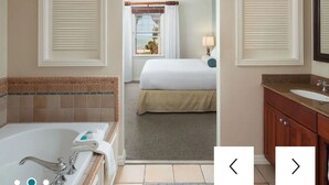Ein Hotelbad mit einer Badewanne, einem Waschbecken und einem Spiegel.