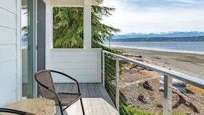 A balcony with a view of a beach and mountains. - Pearl House Beach Retreat (Poulsbo)