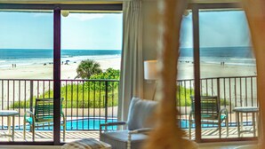 A balcony with a view of a beach and a pool. - Healthier Beachfront Stay - Short Walk to Flagler (New Smyrna Beach)