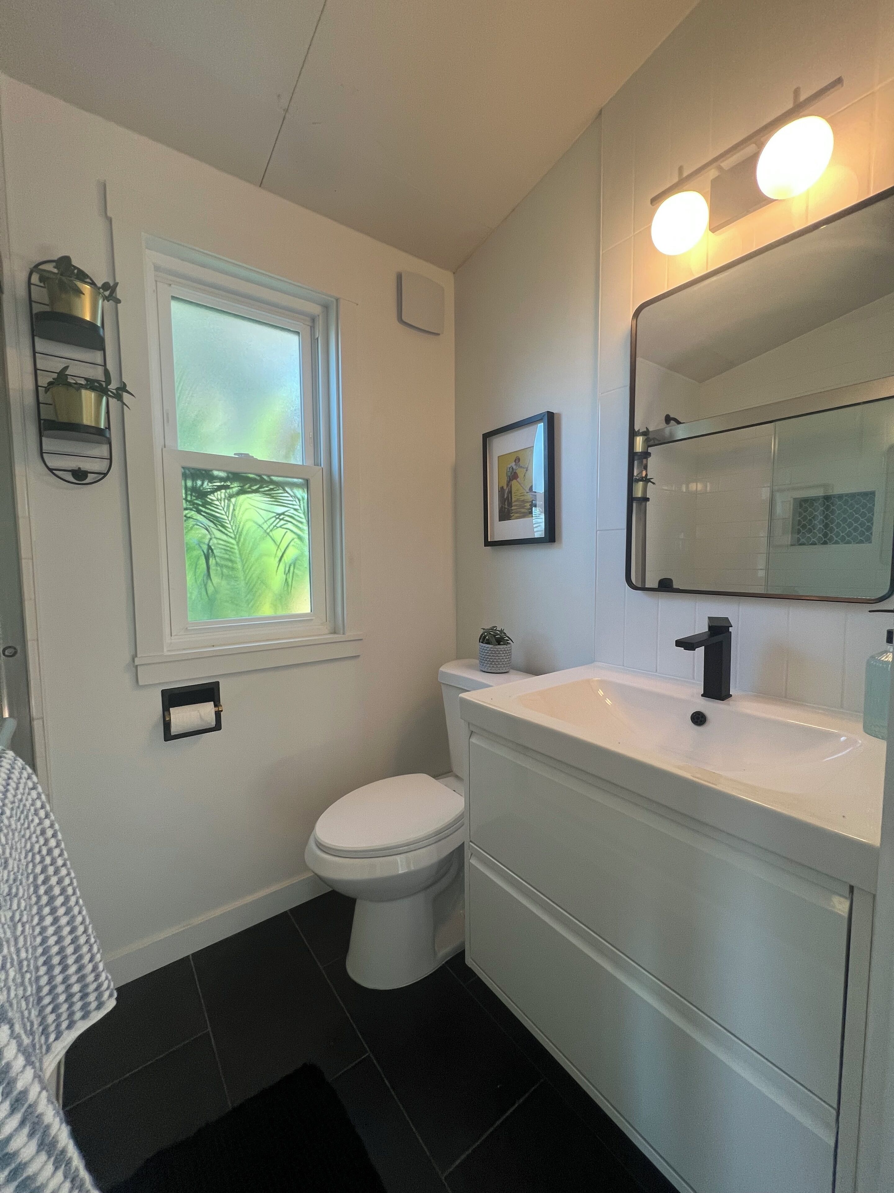 Un baño con inodoro, lavamanos y ventana.