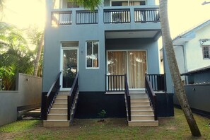 A two-story building with a staircase leading to the entrance, surrounded by greenery. - DADY`S Place `63`- Sunset Villa - 1 Floor - Beach in 2 Min (Hikkaduwa)