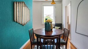 A dining area with a round table, chairs, and a teal accent wall. - Chiado Glamorous flat! FREE PARK! Great WI-FI!! (Lisboa)