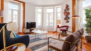 A modern living room with a TV, sofa, chairs, and a coffee table. - Baixa most luminous 3 BDR flat!! Great WI-FI!!! (Lisboa)