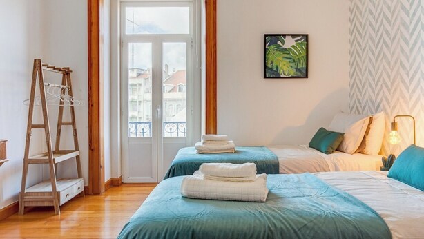 A bedroom with two beds, a wooden ladder, a door leading outside, and a ceiling light fixture. - Baixa most luminous 3 BDR flat!! Great WI-FI!!! (Lisboa)