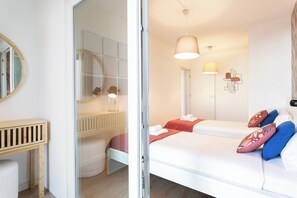 A hotel room with a bed, bedside tables, a mirror, and a wall-mounted light fixture. - Modern 2bdr flat in the city's heart! (Lisboa)