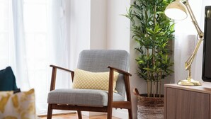 A modern living room with a grey armchair, a small table, a lamp, and a potted plant. - Principe Real beautiful 3 bedrs flat! Great WI-FI! (Lisboa)