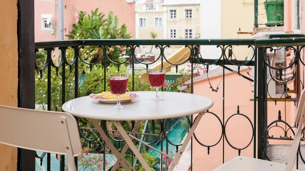 A balcony with a table and two glasses of red beverage, surrounded by a wrought iron railing. - Principe Real beautiful 3 bedrs flat! Great WI-FI! (Lisboa)