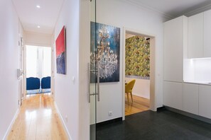 A modern kitchen with white cabinets, a glass door, and a colorful mural. - Lisbon luxury retreat! 2 suites! (Lisboa)
