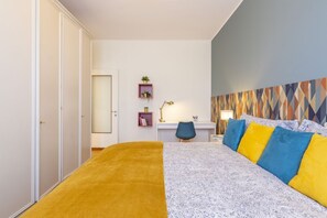 A bedroom with a bed, a desk, a chair, and a wardrobe.