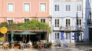 Straßenansicht mit einem Café, Außenbereich und farbenfrohen Gebäuden.