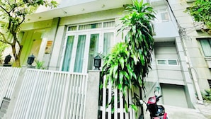 A multi-story residential building with balconies, a gated entrance, and a parked motorcycle. - EMERALD APARTMENTS (Ho Chi Minh City)