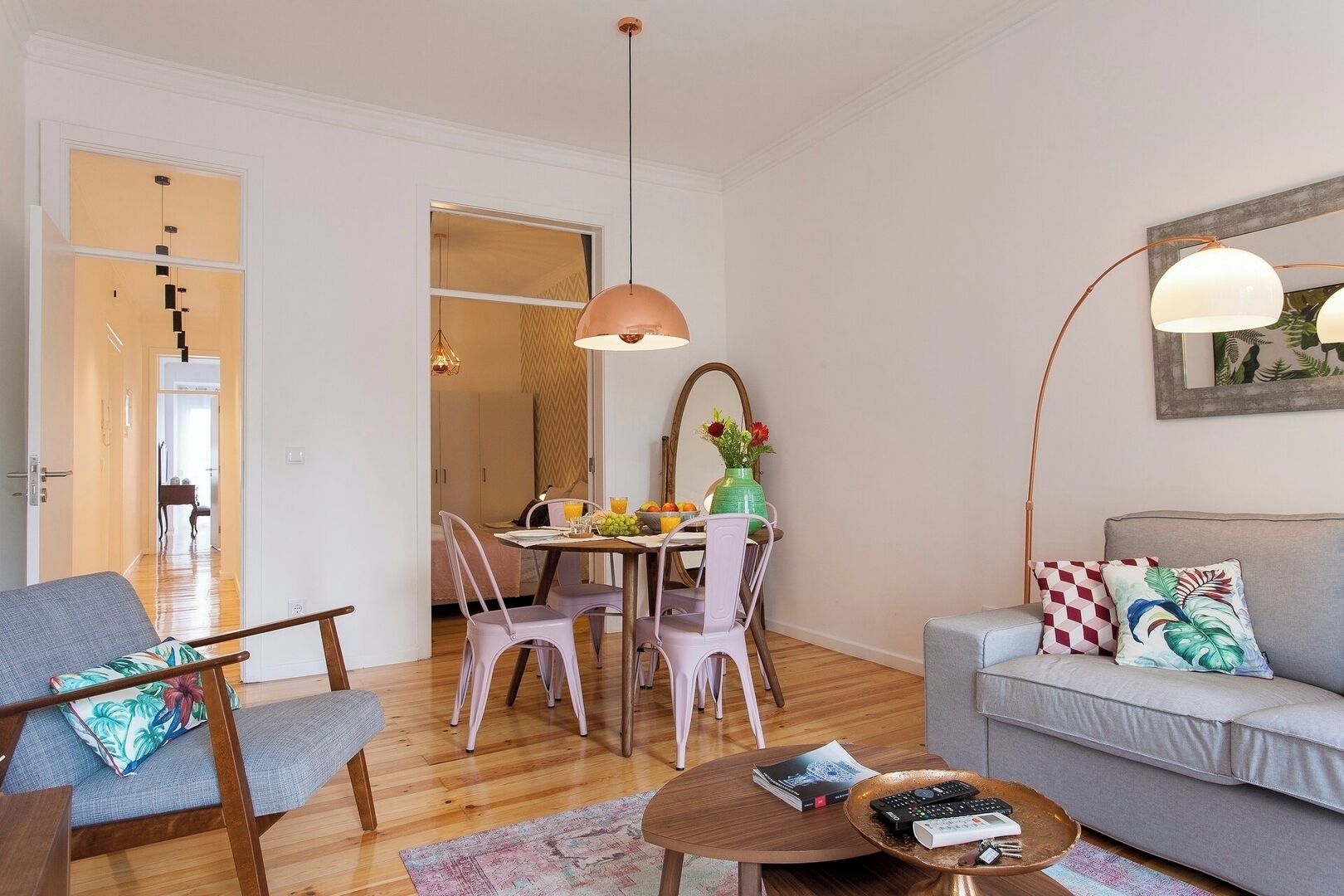 Una sala de estar moderna con sofá, mesa de centro y comedor con sillas y una mesa.