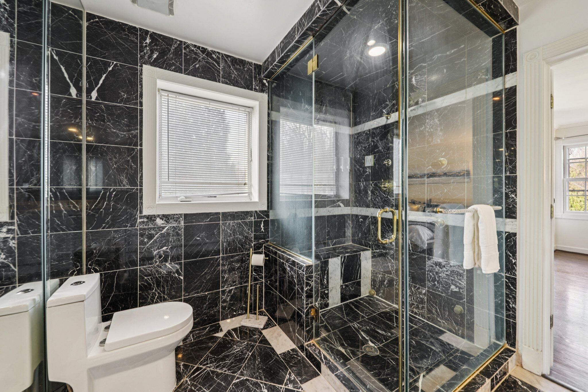 Un bagno moderno con doccia vetrata, un water e un lavandino.