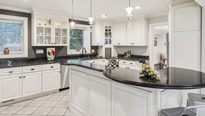 Una cocina moderna con armarios blancos, encimera negra y una isla central.