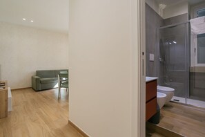 Ein modernes Badezimmer mit Duschkabine aus Glas, Toilette und Waschtisch.
