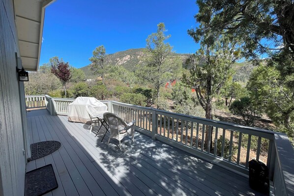 A wooden deck with a covered seating area, a white railing, and a view of a mountainous landscape. - Dog-Friendly Payson Retreat w/ Panoramic Views! (Payson)