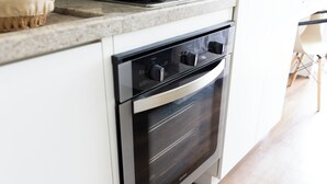 A kitchen with a built-in oven and a microwave above it. - Moderno com AC piscina e academia (São Paulo)