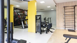 A gym with exercise equipment, a wall-mounted pull-up bar, and a large mirror. - Moderno com AC piscina e academia (São Paulo)