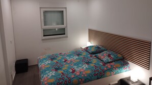 Un dormitorio con una cama, una ventana y una lámpara en el techo.