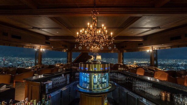 A bar with a panoramic city view, a chandelier, and leather seating. - Moderno com AC academia 24h e rooftop (São Paulo)