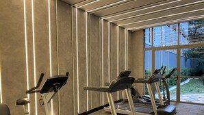 A gym with treadmills and an elliptical machine, large windows, and a view of the outdoors. - Moderno com AC academia 24h e rooftop (São Paulo)