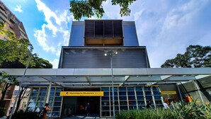 A modern building with a glass entrance and a yellow sign reading "Hygienopolis-Mackenzie". - Moderno com AC academia 24h e rooftop (São Paulo)