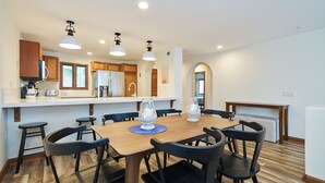 Une cuisine moderne avec des meubles en bois, un îlot central et des luminaires suspendus.