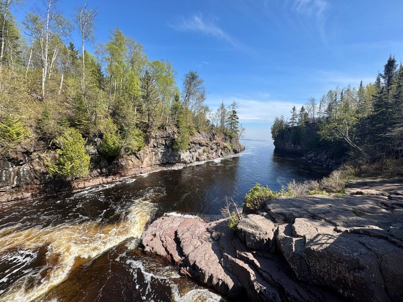A river flowing through a rocky landscape with trees on both sides.