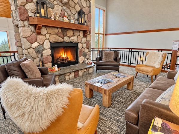 A cozy lobby with a stone fireplace, leather sofas, and a wooden coffee table.