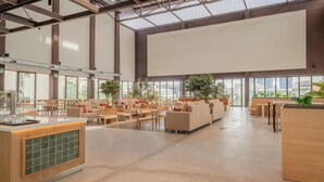 A spacious, well-lit indoor area with seating arrangements and a large screen. - Micampus Foronda 7 (Madrid)