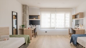 A modern hotel room with two beds, a desk, and a large window. - Micampus Foronda 7 (Madrid)