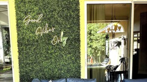 Un área de estar al aire libre moderna con un muro verde y un edificio amarillo.