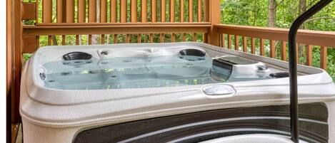 A hot tub on a wooden deck with a natural backdrop.