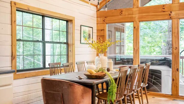 A wooden dining area with a large table, chairs, and a vase with flowers. - NEW LISTING SPECIAL-Mountain Escape Near It All sleeps 8 with 4 bedrooms! (Sevierville)